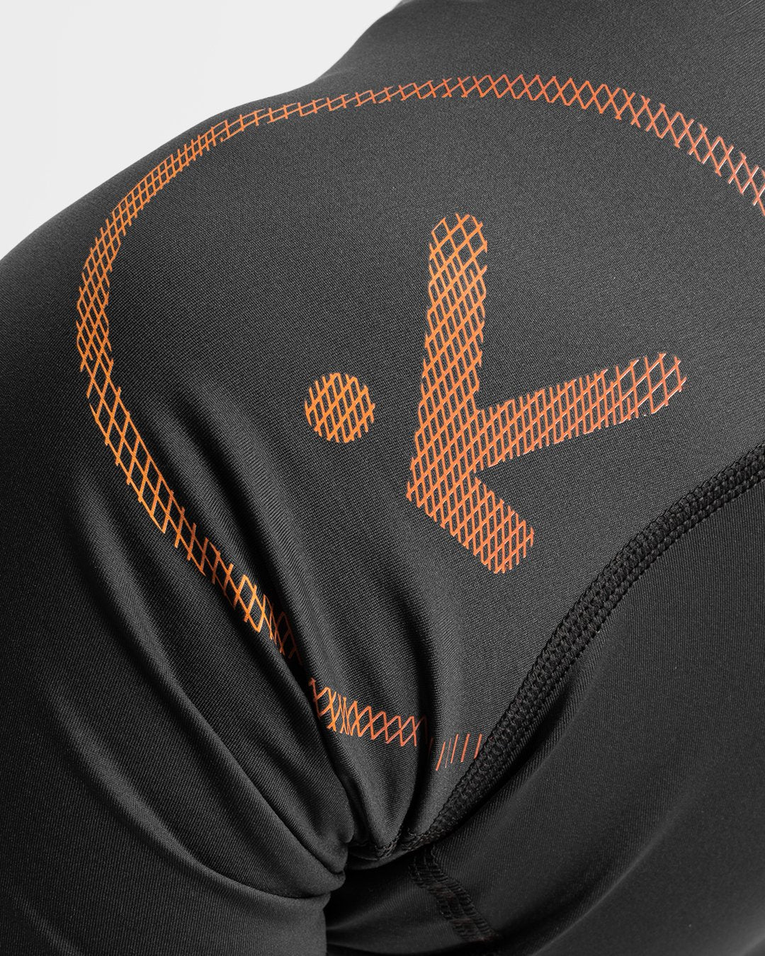 BLACK TOP WITH ORANGE LOGO CLOSE UP VIEW ON WHITE BACKGROUND