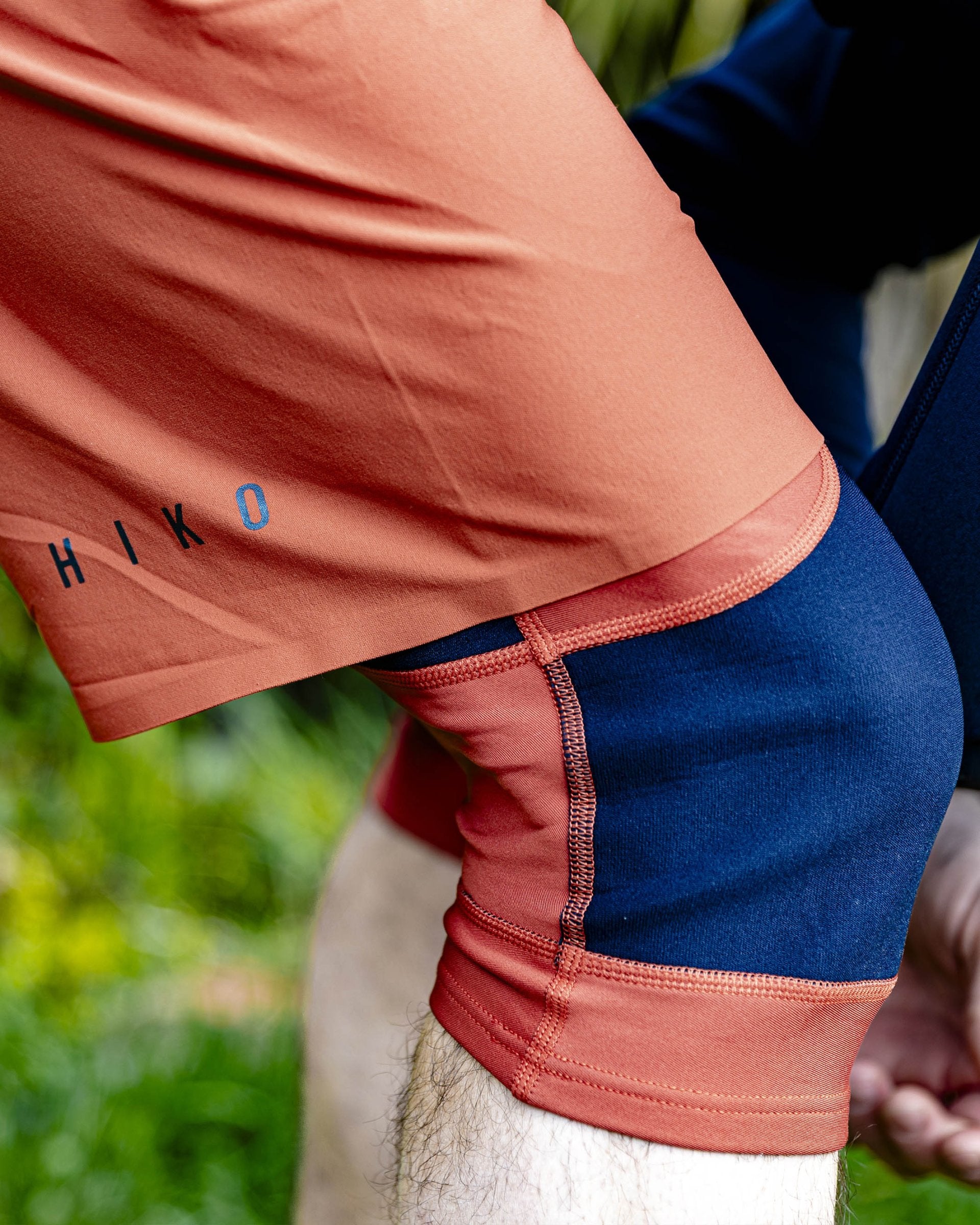 Person wearing a red athletic outfit with 'HIKO' branding, standing outdoors.